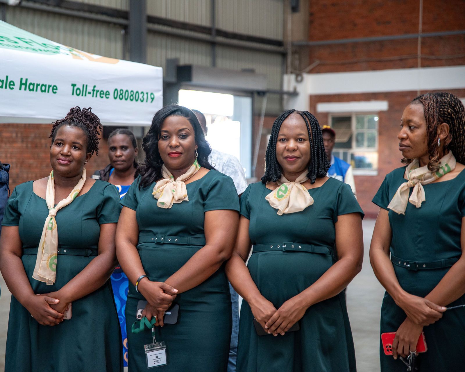 Ethical Sales Floor staff in green uniforms under the branded tent