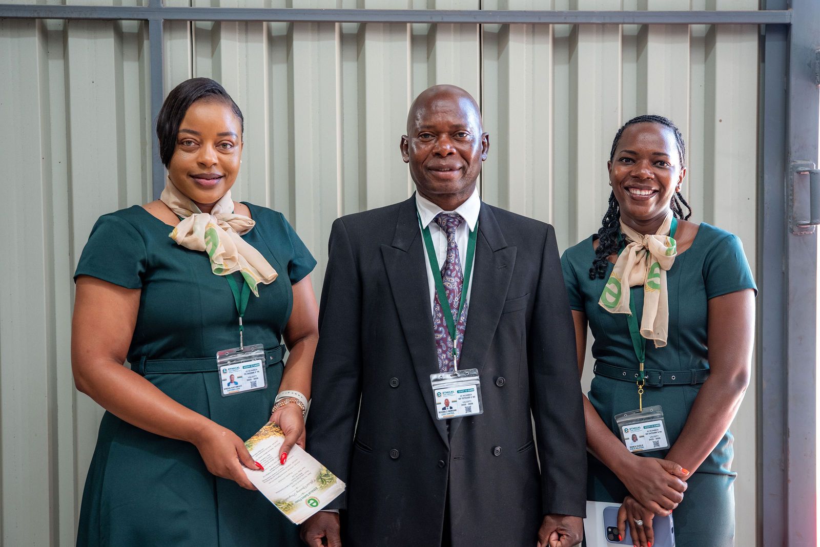 Three Ethical Sales Floor staff members with staff ID cards, smiling