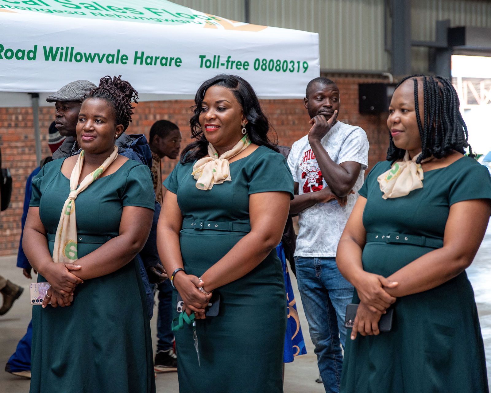 Floor staff in green uniforms standing under the Ethical Sales Floor tent