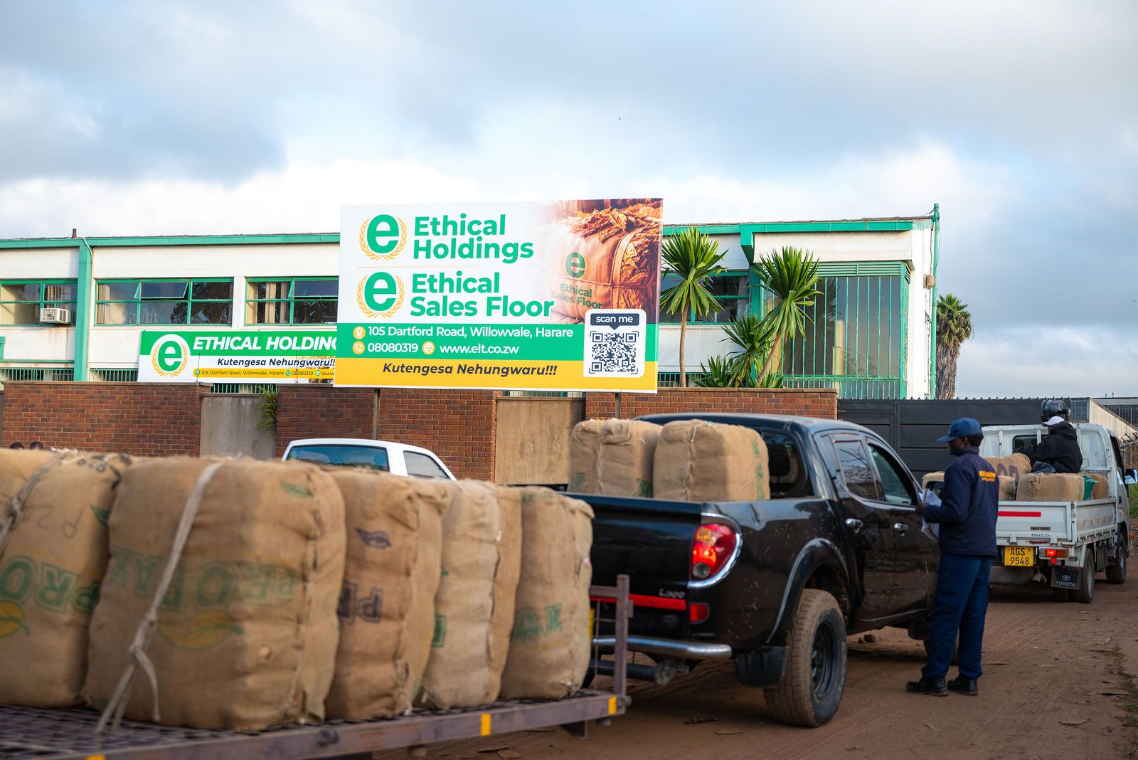 Trucks loaded with tobacco bales queue at the sales floor gate